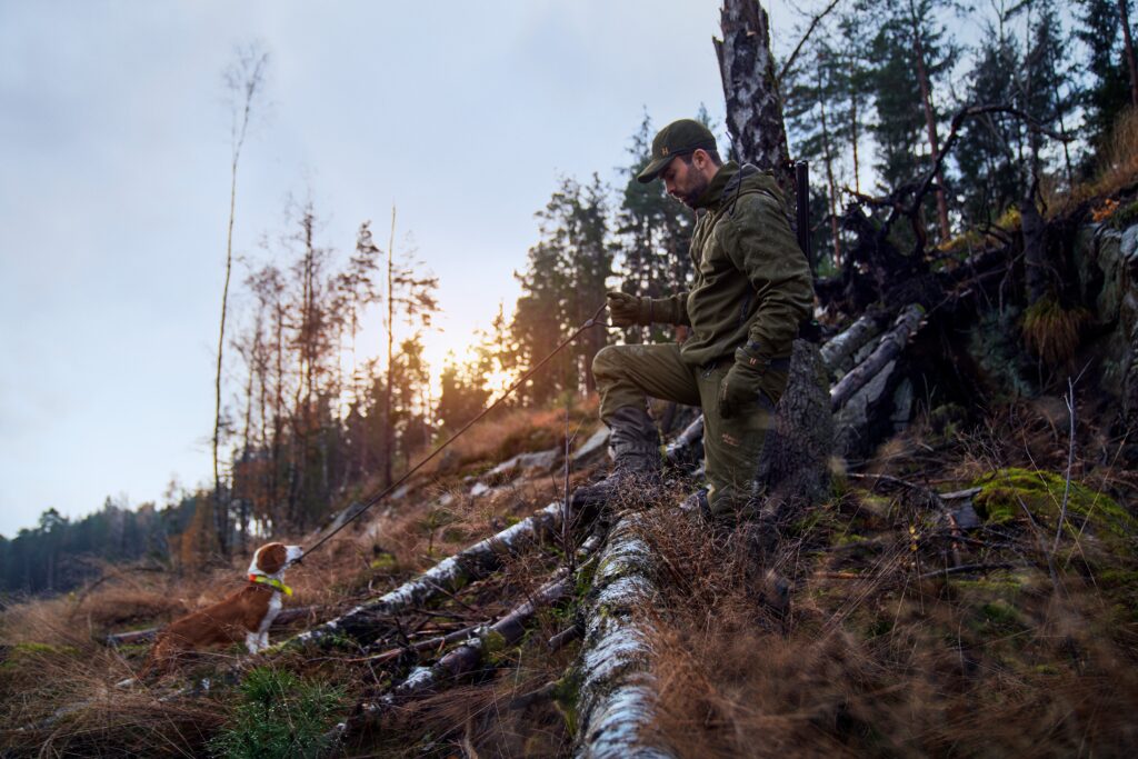 Jägare med hund i skogen